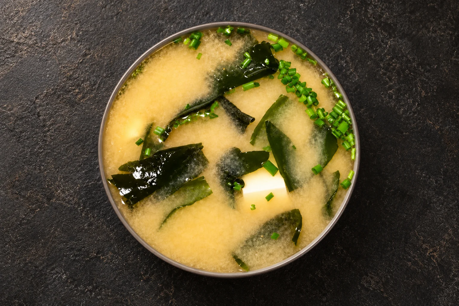 Misosuppe in einer Schale vor dunklem Hintergrund